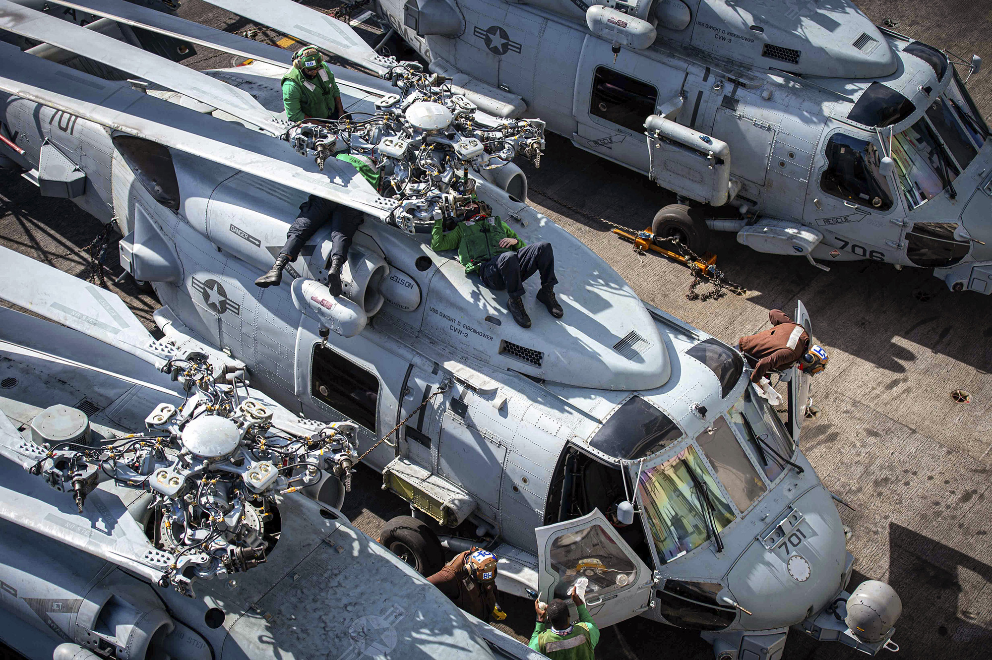 Sailors perform maintenance on an MH-60R Sea Hawk on Jan. 27, 2021, on the flight deck aboard the Nimitz-class aircraft carrier USS Dwight D. Eisenhower (CVN 69) in the Atlantic Ocean.